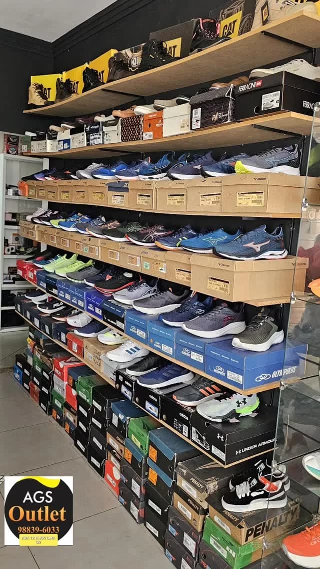 A estante da AGS Outlet: prateleiras de tênis de corrida e caixas empilhadas até o teto