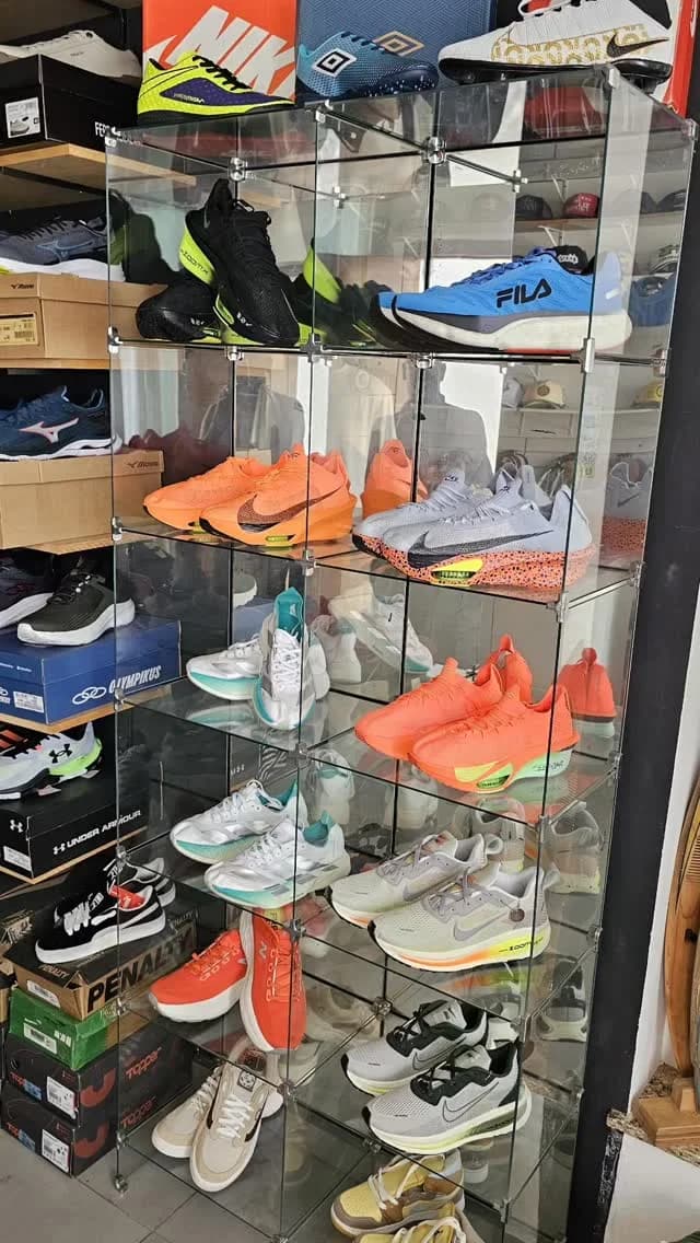 A vitrine de vidro da loja com tênis Fila, Nike, Mizuno e Olympikus nas prateleiras